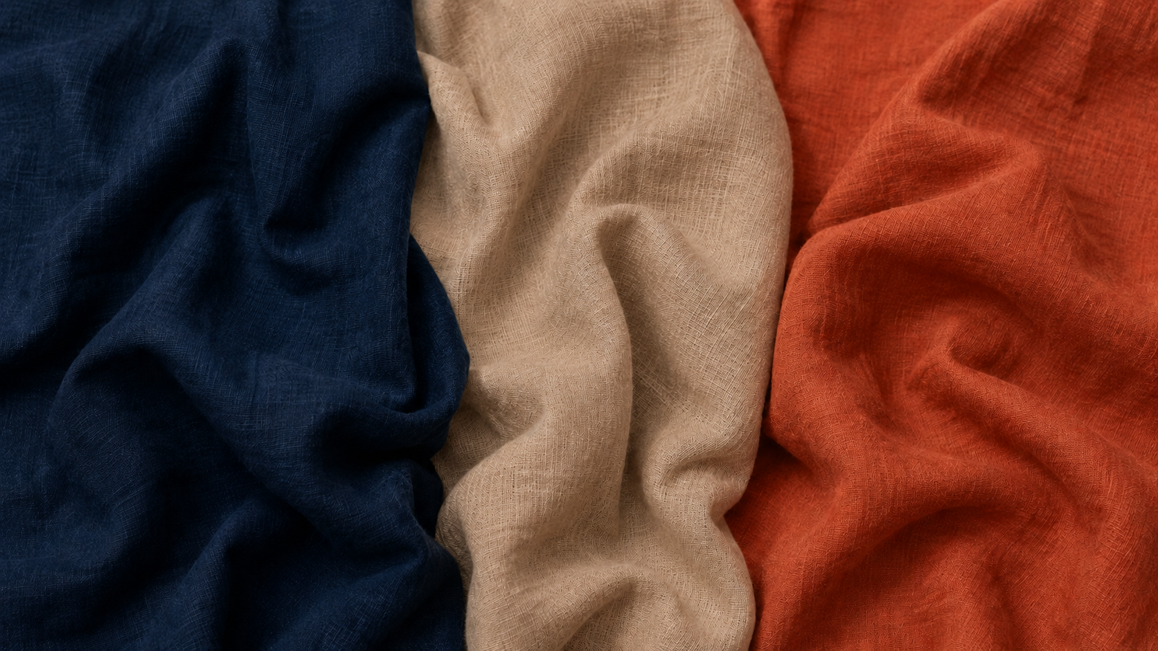 Three different colored organic linen fabrics arranged in a row.