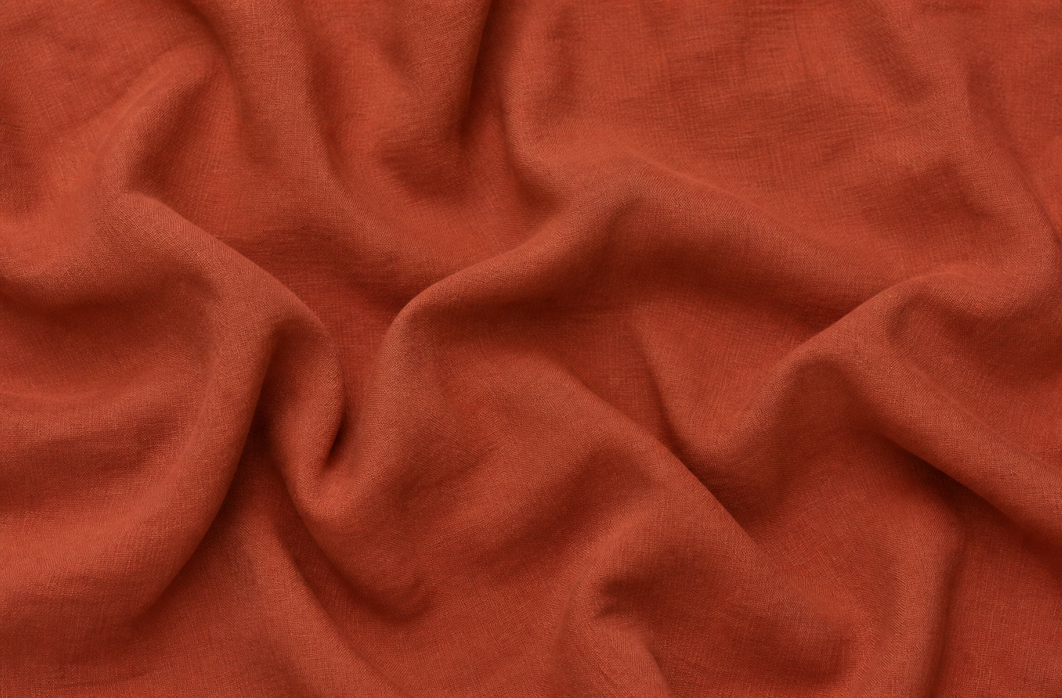 Close up of terracotta coloured organic linen with folds